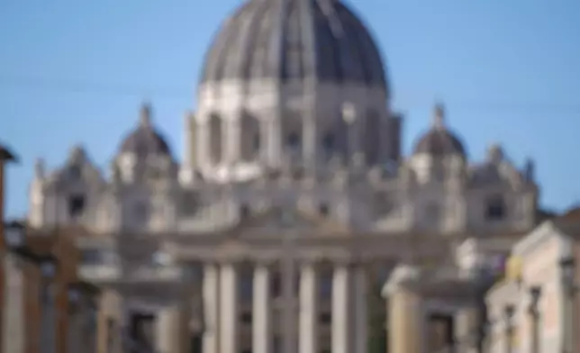 Italian Premier Giorgia Meloni, center, backdropped by St.Peter's Basilica, delivers her speech in Rome, Italy, Monday, Dec. 23, 2024 during the opening ceremony of a new pedestrian area in the nearby of the Vatican, just ahead of the Jubilee Year, an event expected to draw millions of visitors to the Eternal City. (AP Photo/Andrew Medichini)