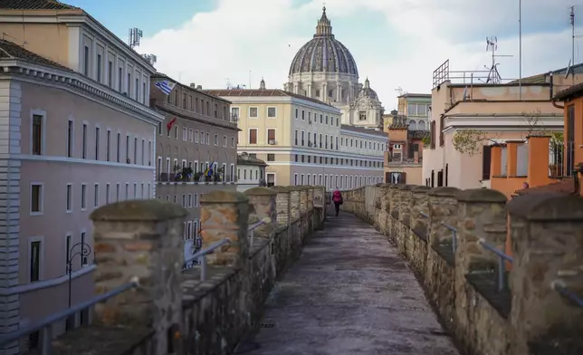 A person walks along the elevated secret narrow 800-meter corridor, known as "Passetto", that runs atop the old Vatican walls between the Popes' Vatican palace and the Castel Sant'Angelo fortress, which was used during the Sack of Rome in 1527 by Pope Clement VII to escape and take refuge in the fortress, as it is reopened to the public just ahead of the Jubilee Year, an event expected to draw millions of visitors to the Eternal City, in Rome, Monday, Dec. 23, 2024. (AP Photo/Andrew Medichini)