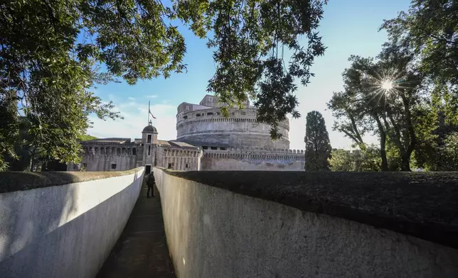 A person walks along the elevated secret narrow 800-meter corridor, known as "Passetto", that runs atop the old Vatican walls between the Popes' Vatican palace and the Castel Sant'Angelo fortress, which was used during the Sack of Rome in 1527 by Pope Clement VII to escape and take refuge in the fortress, as it is reopened to the public just ahead of the Jubilee Year, an event expected to draw millions of visitors to the Eternal City, in Rome, Monday, Dec. 23, 2024. (AP Photo/Andrew Medichini)