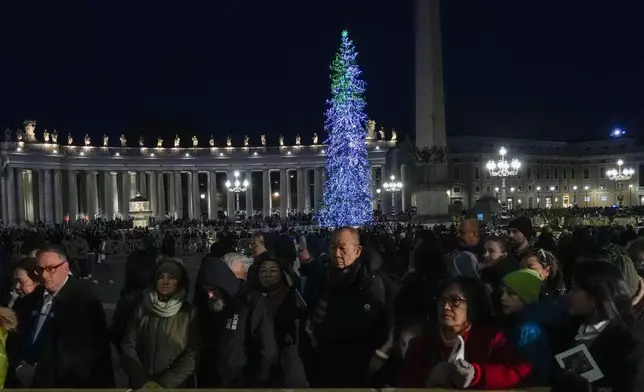 Faithful and pilgrims wait in St. Peter's Square for the opening of the holy door of St. Peter's Basilica at The Vatican, Tuesday, Dec. 24, 2024, marking the start of the Catholic jubiliar year 2025. (AP Photo/Gregorio Borgia)