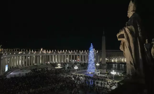 Faithful and pilgrims wait in St. Peter's Square for the opening of the holy door of St. Peter's Basilica at The Vatican, Tuesday, Dec. 24, 2024, marking the start of the Catholic jubiliar year 2025. (AP Photo/Gregorio Borgia)