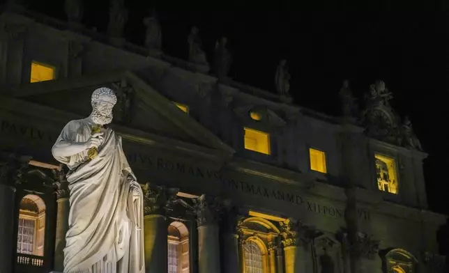 Saint Peter's marble statue made by Giuseppe De Fabris is lit in St. Peter's Square for the opening of the holy door of St. Peter's Basilica at The Vatican, Tuesday, Dec. 24, 2024, marking the start of the Catholic jubiliar year 2025. (AP Photo/Gregorio Borgia)