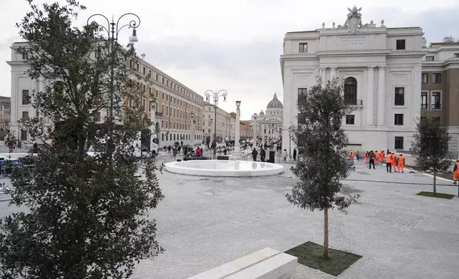 People stroll in the square leading from St. Angelo Castle to the St. Peter's Basilica above a newly inaugurated tunnel, a day before the start of the 2025 Jubilar year, which allows the square to be a fully pedestrian area, in Rome, Monday, Dec. 23, 2024. (AP Photo/Gregorio Borgia)