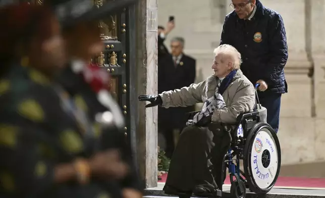 The first pilgrims pass through after Pope Francis opened the Holy Door to mark the opening of the 2025 Catholic Holy Year, or Jubilee, in St. Peter's Basilica, at the Vatican, Tuesday Dec. 24, 2024. (Alberto Pizzoli/Pool via AP)