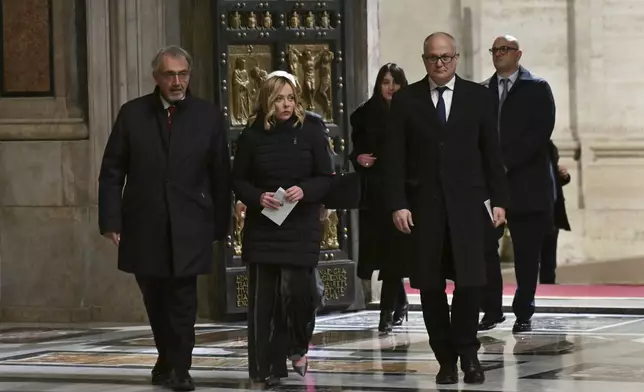 Italy's Prime Minister Giorgia Meloni, center, and Rome's Mayor Roberto Gualtieri, right, pass through after Pope Francis opened the Holy Door to mark the opening of the 2025 Catholic Holy Year, or Jubilee, in St. Peter's Basilica, at the Vatican, Tuesday Dec. 24, 2024. (Alberto Pizzoli/Pool via AP)