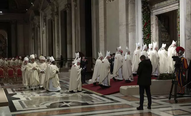 Members of the clergy walk after Pope Francis opened the Holy Door to mark the opening of the 2025 Catholic Holy Year, or Jubilee, in St. Peter's Basilica, at the Vatican, Tuesday Dec. 24, 2024. (Remo Casilli/Pool via AP)