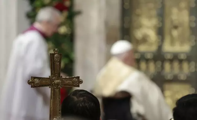 Pope Francis opens the Holy Door to mark the opening of the 2025 Catholic Holy Year, or Jubilee, in St. Peter's Basilica, at the Vatican, Tuesday Dec. 24, 2024. (Remo Casilli/Pool via AP)