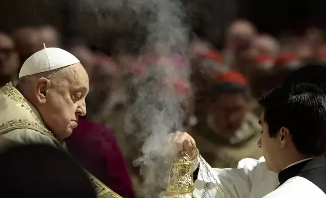 Pope Francis, left, celebrates a Christmas Eve Mass on the day the Pope opens the Holy Door to mark the opening of the 2025 Catholic Holy Year, or Jubilee, in St. Peter's Basilica, at the Vatican, Dec. 24, 2024. (Remo Casilli/Pool Photo via AP)