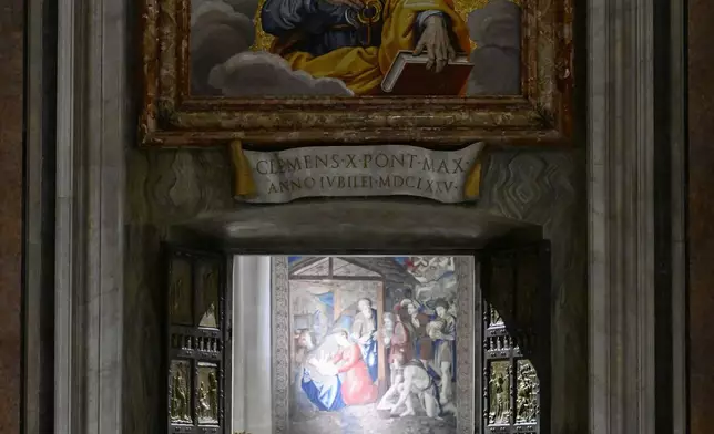 In this image released by Vatican Media, Pope Francis opens the holy door marking the start of the Catholic jubilar year 2025 before presiding over the Christmas Eve Mass in St. Peter's Basilica at The Vatican, Tuesday, Dec. 24, 2024. (AP Photo/Vatican Media, HO)