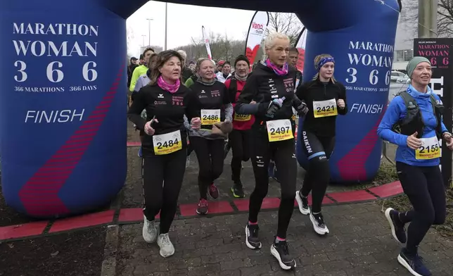 Belgian ultra runner Hilde Dosogne, center, runs during her 366th consecutive marathon in Ghent, Belgium, Tuesday, Dec. 31, 2024. (AP Photo/Virginia Mayo)