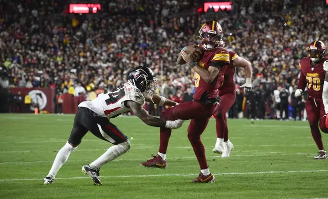 Washington Commanders quarterback Jayden Daniels (5) scrambles against Atlanta Falcons cornerback A.J. Terrell (24) in overtime during an NFL football game, Sunday, Dec. 29, 2024, in Landover, Md. The Commanders won 30-24. (AP Photo/Nick Wass)