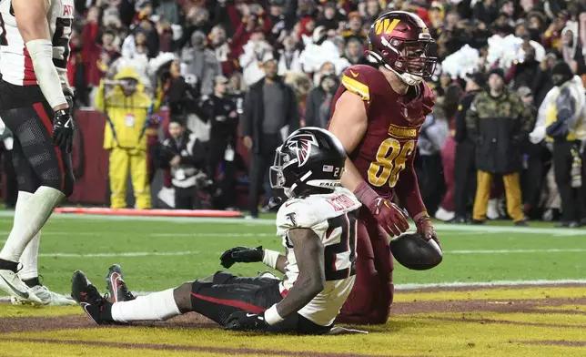 Washington Commanders tight end Zach Ertz (86) scores the winning touchdown against Atlanta Falcons cornerback Dee Alford (20) in overtime during an NFL football game, Sunday, Dec. 29, 2024, in Landover, Md. The Commanders won 30-24. (AP Photo/Nick Wass)