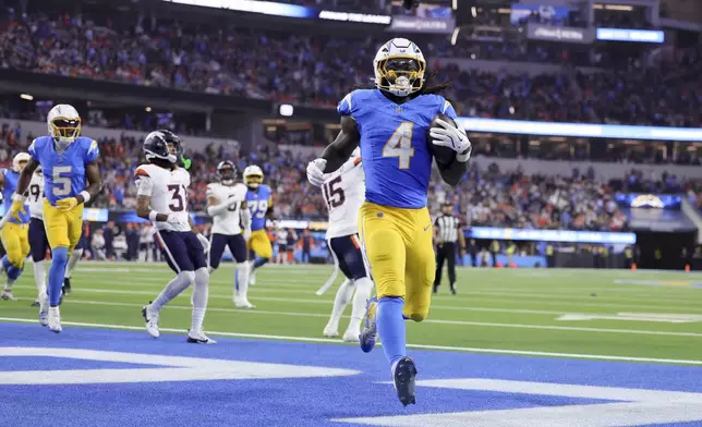 Los Angeles Chargers running back Gus Edwards (4) scores a rushing touchdown during the second half an NFL football game against the Denver Broncos, Thursday, Dec. 19, 2024, in Inglewood, Calif. (AP Photo/Ryan Sun)