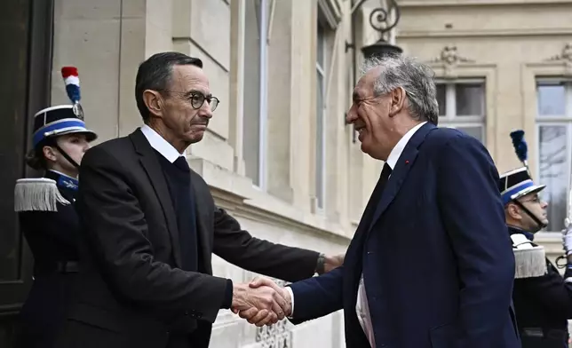 French Minister of the Interior Bruno Retailleau, left, welcomes French Prime Minister Francois Bayrou to attend a meeting at the Interior Ministry in Paris, Monday Dec. 23, 2024, following the cyclone Chido's passage over the French Indian Ocean territory of Mayotte. Hard-right Bruno Retailleau stays on as interior minister, with responsibility for France's security and migration policy. (Julien de Rosa, Pool via AP)