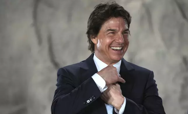 Tom Cruise smiles as he receives a Navy Distinguished Public Service Award from The United States Secretary of the Navy Carlos Del Toro presents at the Longcross South Studios, in Runnymede, Surrey, England, Tuesday, Dec. 17, 2024. (AP Photo/Kin Cheung)