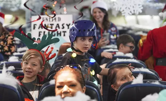 Participants prepare for take off during the United Airlines annual "fantasy flight" to a fictional North Pole at Denver International Airport, Saturday, Dec. 14, 2024, in Denver. (AP Photo/David Zalubowski)