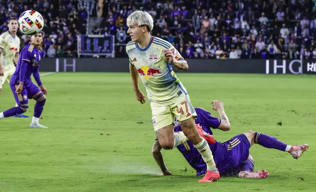 New York Red Bulls defender John Tolkin (47) gets ball away from Orlando City midfielder Dagur Dan Þórhallsson, right, during the first half of an MLS Eastern Conference final soccer match, Saturday, Nov. 30, 2024, in Orlando, Fla. (AP Photo/Kevin Kolczynski)