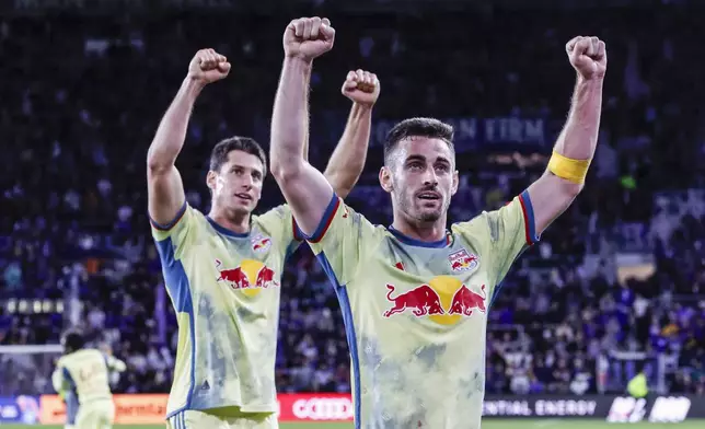 New York Red Bulls defender Dylan Nealis, right, and defender Sean Nealis, left, react to fans after winning against Orlando City in an MLS Eastern Conference final soccer match, Saturday, Nov. 30, 2024, in Orlando, Fla. (AP Photo/Kevin Kolczynski)