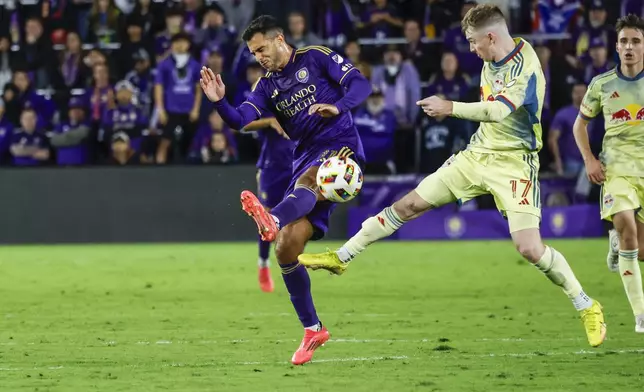 New York Red Bulls forward Cameron Harper (17) and Orlando City midfielder Martín Ojeda, left, go for the ball during the second half of an MLS Eastern Conference final soccer match, Saturday, Nov. 30, 2024, in Orlando, Fla. (AP Photo/Kevin Kolczynski)