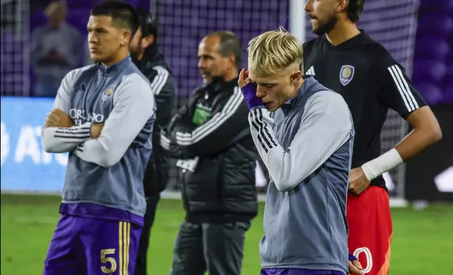 Members of Orlando City watch the trophy presentation to the winning New York Red Bulls after the MLS Eastern Conference final soccer match, Saturday, Nov. 30, 2024, in Orlando, Fla. (AP Photo/Kevin Kolczynski)