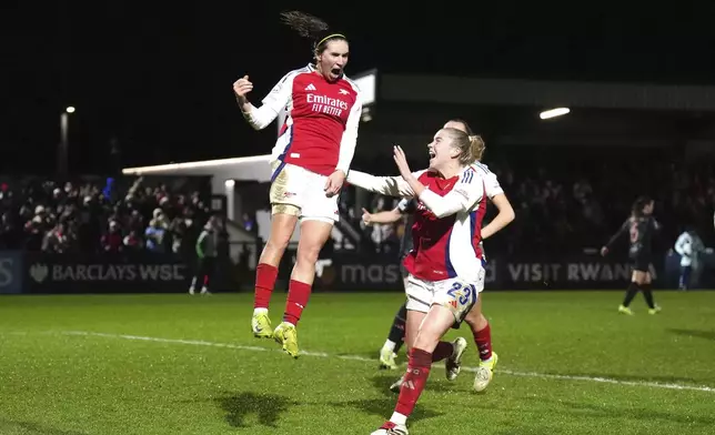 Arsenal's Mariona Caldentey, left,celebrates scoring their side's third goal of the game from the penalty spot against Bayern Munich during a UEFA Women's Champions League soccer match at Meadow Park, Wednesday, Dec. 18, 2024, in Borehamwood, England. (John Walton/PA via AP)