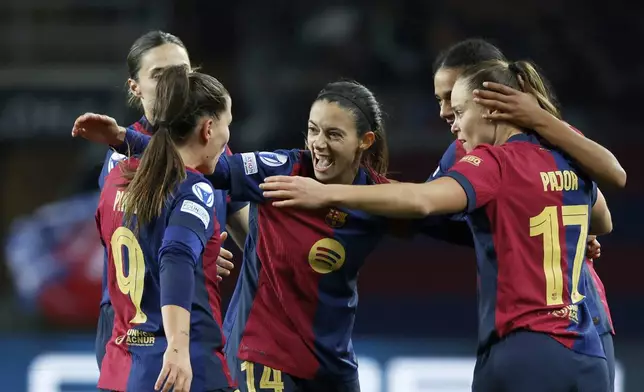 Barcelona's Aitana Bonmati, center, celebrates after scoring her side's second goal during the women's Champions League group D soccer match between FC Barcelona and Manchester City at the Olympic Stadium in Barcelona, Spain, Wednesday, Dec. 18, 2024. (AP Photo/Joan Monfort)