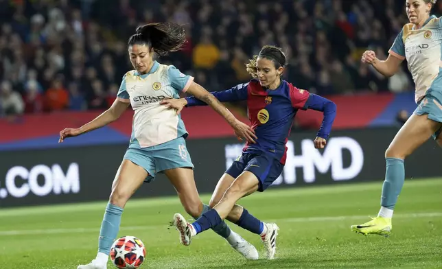 Barcelona's Aitana Bonmati scores her side's second goal past Manchester City's Leila Ouahabi, left, during the women's Champions League group D soccer match between FC Barcelona and Manchester City at the Olympic Stadium in Barcelona, Spain, Wednesday, Dec. 18, 2024. (AP Photo/Joan Monfort)