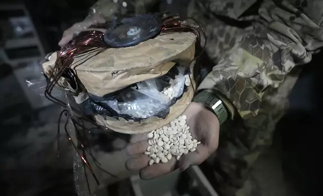 A Syrian member of the rebel shows amphetamine pills known as Captagon hidden inside an electrical component at a warehouse where the drug was manufactured before the fall of Bashar Assad's government at a facility in Douma city, outskirts of Damascus, Syria, Friday, Dec. 13, 2024. (AP Photo/Hussein Malla)