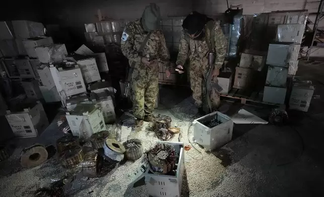 Syrian members of the rebel group inspecting electrical components that were used to hide amphetamine pills known as Captagon hidden at the warehouse where the drug was manufactured before the fall of Bashar Assad government at a facility in Douma city, outskirts of Damascus, Syria, Friday, Dec. 13, 2024. (AP Photo/Hussein Malla)