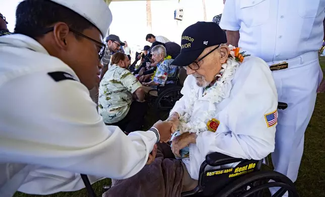 Ira "Ike" Schab, 104, from Beaverton, Ore., who survived the attack on Pearl Harbor as a sailor on the USS Dobbin, right, talks with Navy Petty Officer 2nd Class Quoc Vu after the 83rd Pearl Harbor Remembrance Day ceremony, Saturday, Dec. 7, 2024, in Honolulu. (AP Photo/Mengshin Lin)