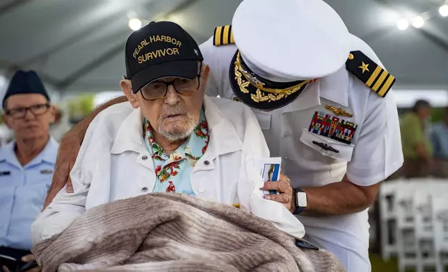 Pearl Harbor survivor Ira "Ike" Schab, left, talks to his son, retired Navy Cmdr. Karl Schab before the 83rd Pearl Harbor Remembrance Day ceremony, Saturday, Dec. 7, 2024, in Honolulu. (AP Photo/Mengshin Lin)