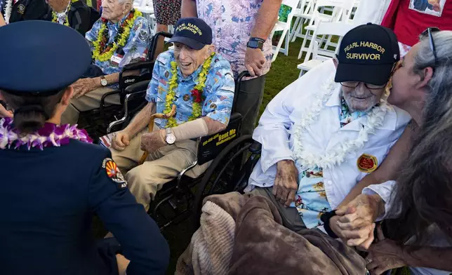 Pearl Harbor survivors Ken Stevens, 102, of Powers, Ore., left, and Ira "Ike" Schab, 104, from Beaverton, Ore., talk to attendees after the 83rd Pearl Harbor Remembrance Day ceremony, Saturday, Dec. 7, 2024, in Honolulu. (AP Photo/Mengshin Lin)