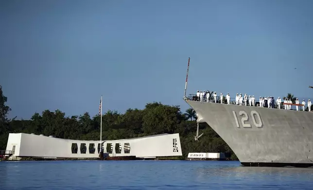 Sailors aboard the USS Carl M. Levin render honors while passing the USS Arizona Memorial and the sunken battleship the USS Arizona during the 83rd Pearl Harbor Remembrance Day ceremony, Saturday, Dec. 7, 2024, in Honolulu. (AP Photo/Mengshin Lin)