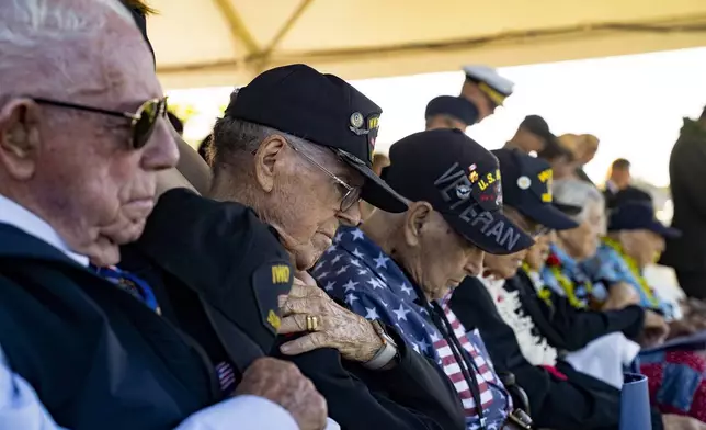 World War II veterans bow their heads during a prayer for the 83rd Pearl Harbor Remembrance Day ceremony, Saturday, Dec. 7, 2024, in Honolulu. (AP Photo/Mengshin Lin)