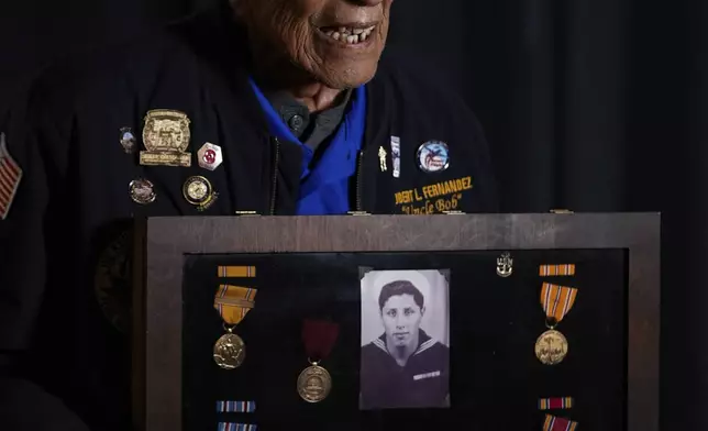 Pearl Harbor Navy veteran Bob Fernandez poses for a photograph with medals from his military service, Tuesday, Nov. 19, 2024, in Lodi, Calif. (AP Photo/Godofredo A. Vásquez)