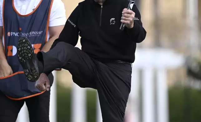 Gary Player, right, celebrates after making a putt on the 18th green as his son Wayne Player looks on during the final round of the PNC Championship golf tournament, Sunday, Dec. 22, 2024, in Orlando, Fla. (AP Photo/Phelan M. Ebenhack)