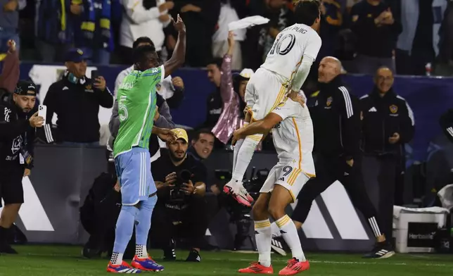 Los Angeles Galaxy forward Dejan Joveljic, right, celebrates his goal with midfielder Riqui Puig (10) during the second half of an MLS Western Conference final soccer match against the Seattle Sounders, Saturday, Nov. 30, 2024, in Carson, Calif. (AP Photo/Etienne Laurent)