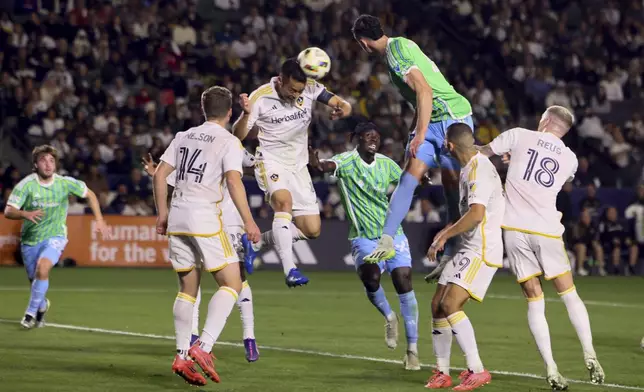 Seattle Sounders defender Nathan, right center vies for a header against Los Angeles Galaxy defender Maya Yoshida, left center, during the first half of an MLS Western Conference final soccer match, Saturday, Nov. 30, 2024, in Carson, Calif. (AP Photo/Etienne Laurent)