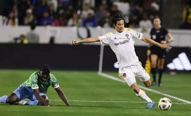 Los Angeles Galaxy defender Miki Yamane, right, shoots past Seattle Sounders forward Georgi Minoungou during the first half of an MLS Western Conference final soccer match, Saturday, Nov. 30, 2024, in Carson, Calif. (AP Photo/Etienne Laurent)