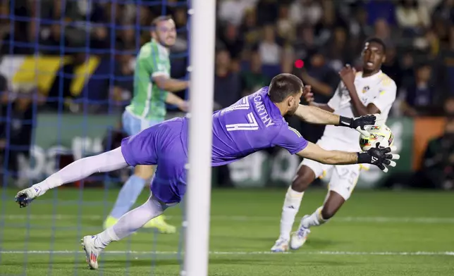 Los Angeles Galaxy goalkeeper John McCarthy (77) stops a shot on goal during the first half of an MLS Western Conference final soccer match against the Seattle Sounders, Saturday, Nov. 30, 2024, in Carson, Calif. (AP Photo/Etienne Laurent)