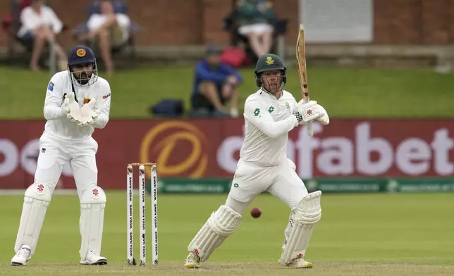 South Africa's Kyle Verreynne, right, plays a shot as Sri Lanka's Kusal Mendis watches on during the first day of the second Test cricket match between South Africa and Sri Lanka, at St George's Park in Gqeberha, South Africa, Thursday, Dec. 5, 2024. (AP Photo/Themba Hadebe)