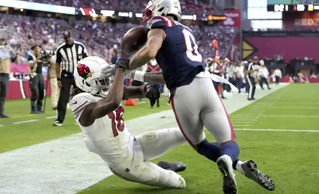 New England Patriots cornerback Christian Gonzalez (0) breaks up a pass intended for Arizona Cardinals wide receiver Marvin Harrison Jr. (18) during the first half of an NFL football game, Sunday, Dec. 15, 2024, in Glendale, Ariz. (AP Photo/Rick Scuteri)