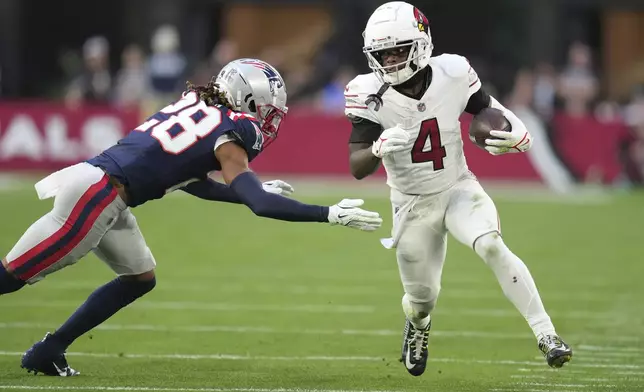 Arizona Cardinals wide receiver Greg Dortch (4) runs as New England Patriots cornerback Alex Austin (28) defends during the second half of an NFL football game, Sunday, Dec. 15, 2024, in Glendale, Ariz. (AP Photo/Ross D. Franklin)