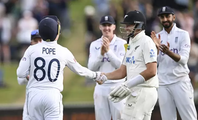 England's Ollie Pope and teammates welcome New Zealand's Tim Southee to the crease with a guard of honour during play on day three of the third cricket test between England and New Zealand in Hamilton, New Zealand, Monday, Dec. 16, 2024. (Andrew Cornaga/Photosport via AP)