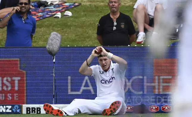 England's Matthew Potts reacts after taking a catch to dismiss New Zealand's Daryl Mitchell during play on day three of the third cricket test between England and New Zealand in Hamilton, New Zealand, Monday, Dec. 16, 2024. (Andrew Cornaga/Photosport via AP)