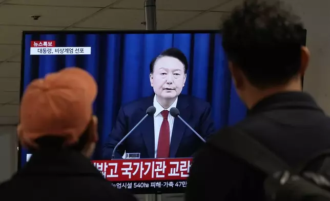 People watch a TV screen showing South Korean President Yoon Suk Yeol's televised briefing at a bus terminal in Seoul, South Korea, Tuesday, Dec. 3, 2024. (AP Photo/Ahn Young-joon)