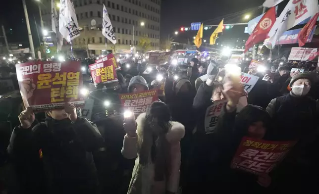 People gather to demand South Korean President Yoon Suk Yeol to step down in front of the National Assembly in Seoul, South Korea, Wednesday, Dec. 4, 2024. (AP Photo/Ahn Young-joon)