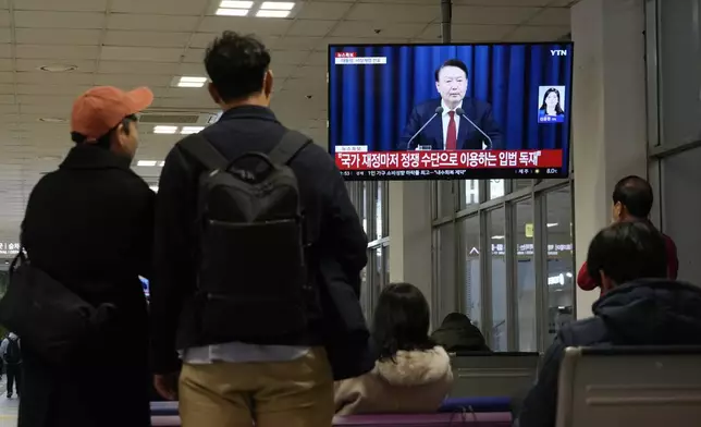 People watch a TV screen showing South Korean President Yoon Suk Yeol's televised briefing at a bus terminal in Seoul, South Korea, Tuesday, Dec. 3, 2024. (AP Photo/Ahn Young-joon)