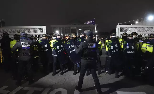 Police officers stand guard in front of the National Assembly in Seoul, South Korea, Tuesday, Dec. 3, 2024. (AP Photo/Lee Jin-man)