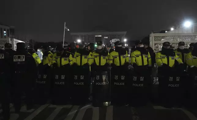 Police officers stand guard in front of the National Assembly in Seoul, South Korea, Tuesday, Dec. 3, 2024. (AP Photo/Lee Jin-man)